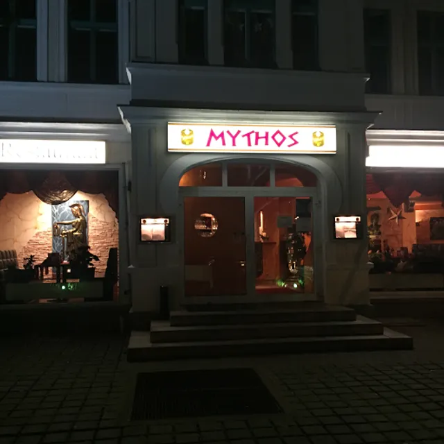 Leuchtendes MYTHOS-Schild am Restaurant in der Abenddämmerung